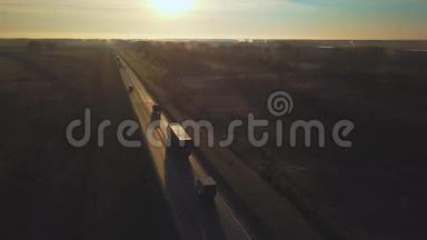 空气：运送卡车驶向太阳。 集装箱的汽车在通往日落的道路上行驶。 卡车